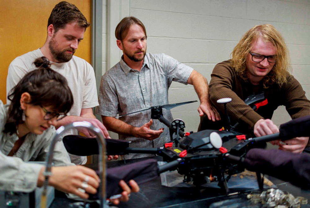 Doug Edmonds and his graduate assistants configuring a drone