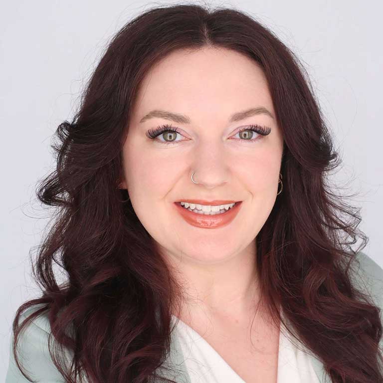 A headshot of Haley Russ, who wears a white shirt and poses against a white background.